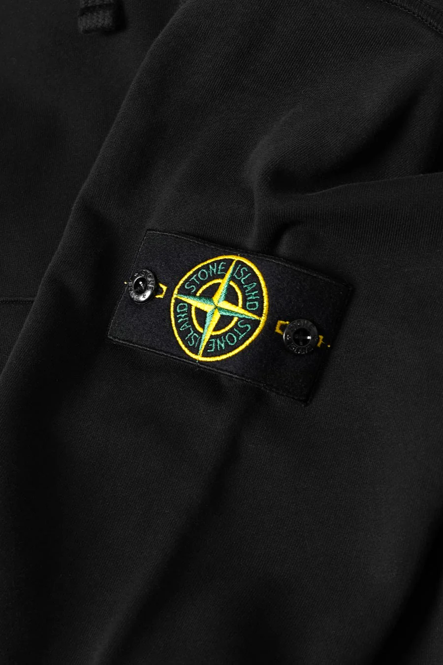 Stone Island badge attached to a black sleeve
